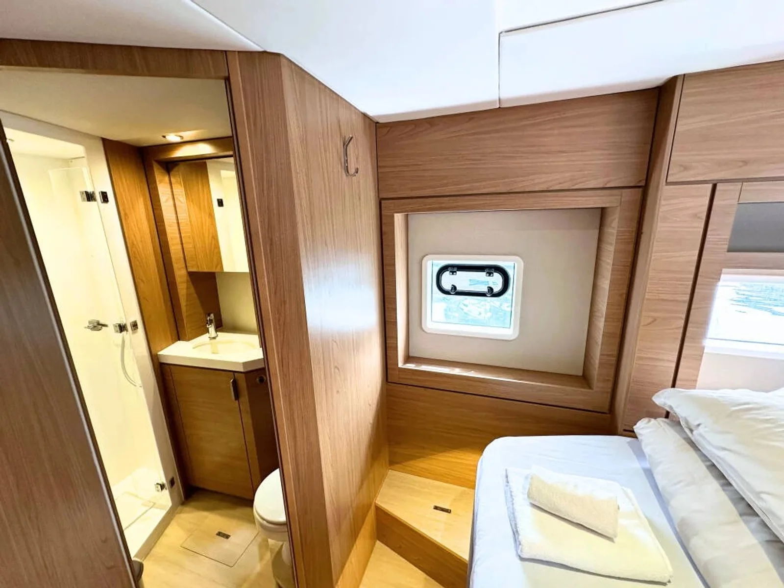 Bali 4.6 guest cabin opening onto its bathroom with a glass shower cubicle, wooden vanity and toilet